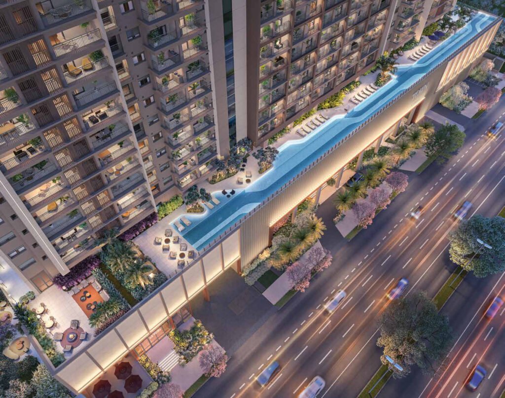 Perspectiva aérea da piscina de 100 metros no 3º pavimento do Town Residences by Lindenberg, com deck, ilhas de vegetação e a avenida ao lado